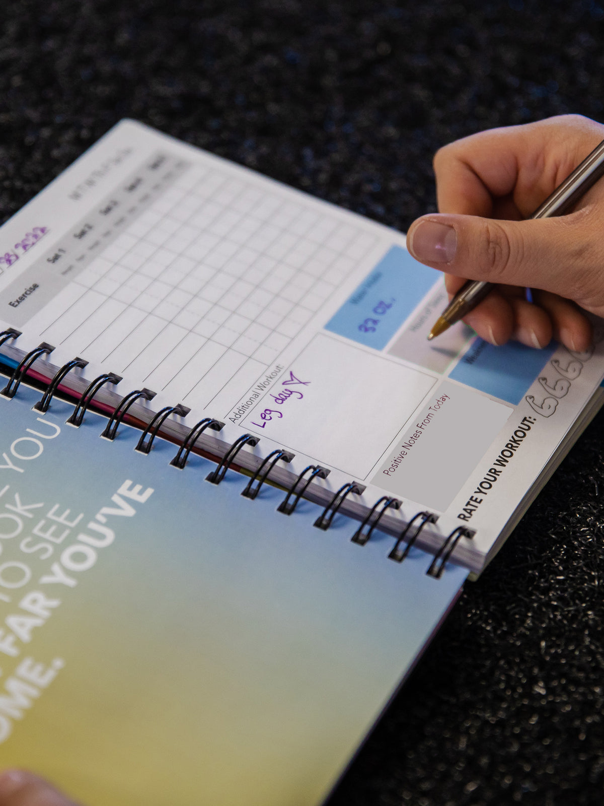 Writing with a pen inside a fitness journal